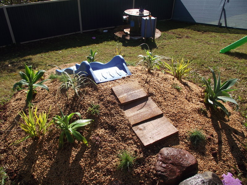 Hill Slide Fun from The Empowered Educator! Add a climbing challenge to your outdoor play area with this simple DIY mound or hill slide. No hardware required and easy to remove when no longer needed! Perfect project for parents, educators and early childhood teachers who value engaging outdoor play spaces! #outdoorplay #diy #outdoorspace #backyard #naturalplay #hillslidefun