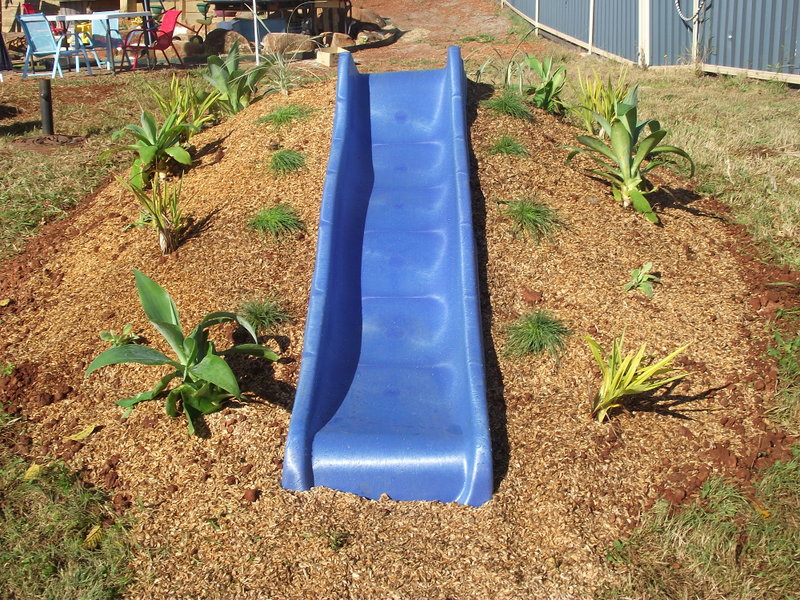 Hill Slide Fun from The Empowered Educator! Add a climbing challenge to your outdoor play area with this simple DIY mound or hill slide. No hardware required and easy to remove when no longer needed! Perfect project for parents, educators and early childhood teachers who value engaging outdoor play spaces! #outdoorplay #diy #outdoorspace #backyard #naturalplay #hillslidefun