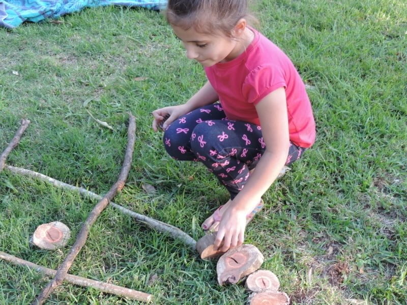 8 easy ideas to introduce play based learning activities into children's outdoor play using wooden cookies, nature and simple DIY resources. Fantastic ideas here for early childhood teachers, educators and homeschool!