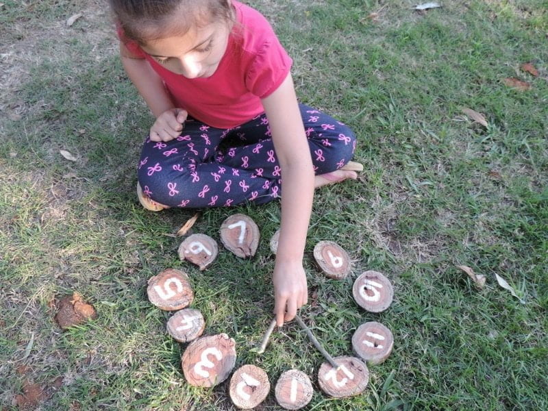 8 easy ideas to introduce play based learning activities into children's outdoor play using wooden cookies, nature and simple DIY resources. Fantastic ideas here for early childhood teachers, educators and homeschool!