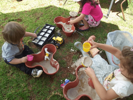 Shoes on in the sandpit with toys buried to find